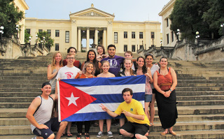 Students standing on the steps of Universidad de Habana holding the Cuban flag in La Habana, Cuba.