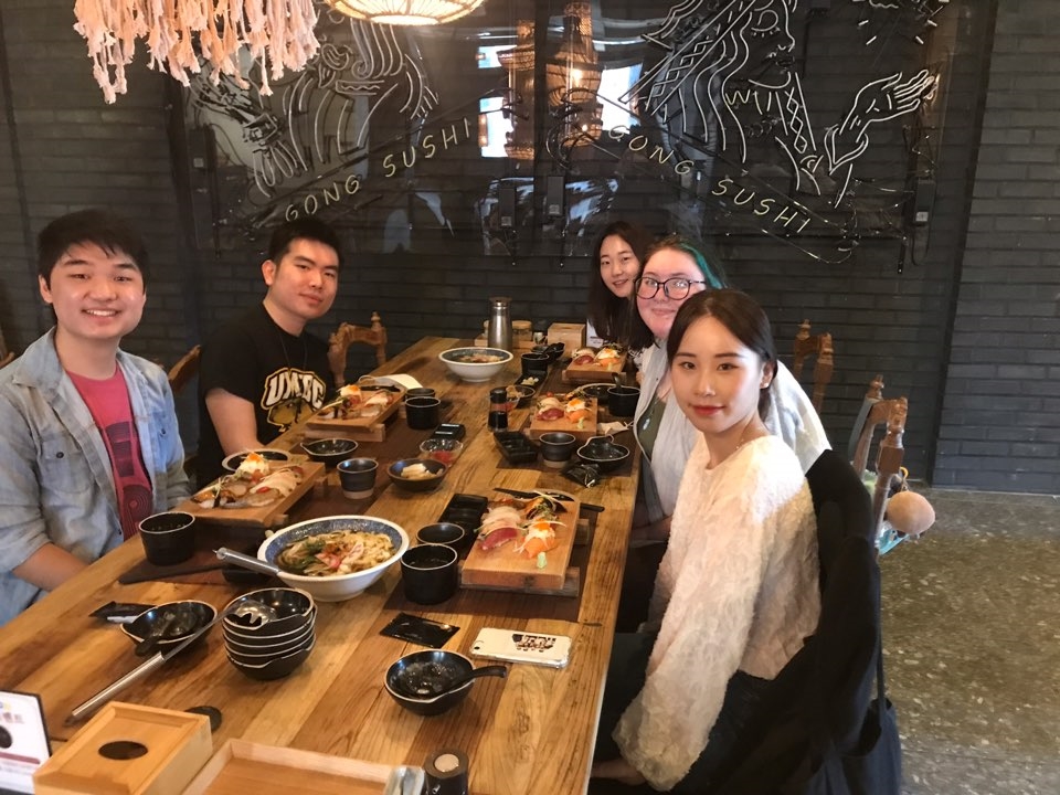 A group of people eating traditional Korean food at a restaurant in Gwangju, Korea.