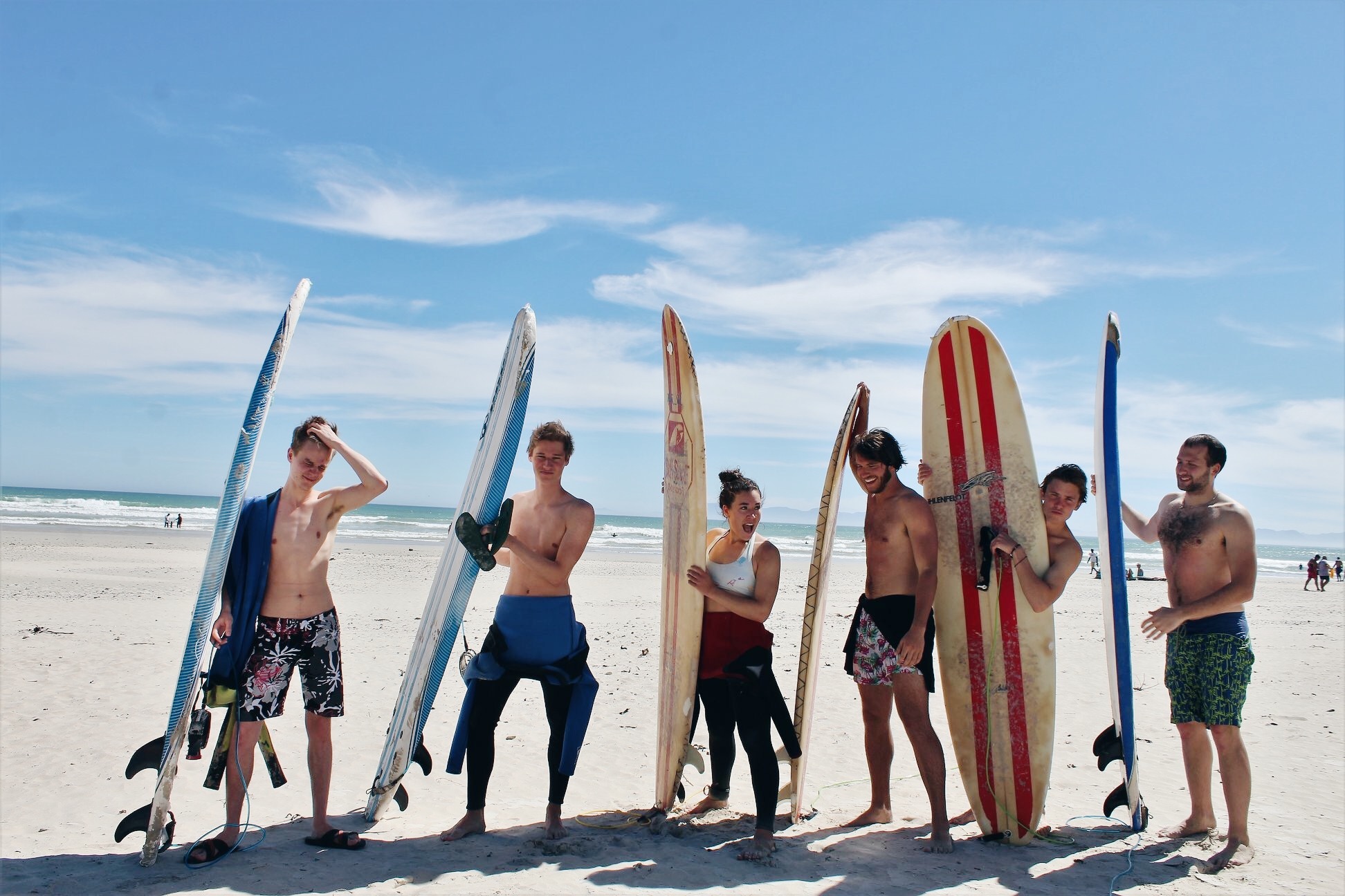 Students on the beach with their surfboards in Stellenbosch, South Africa.