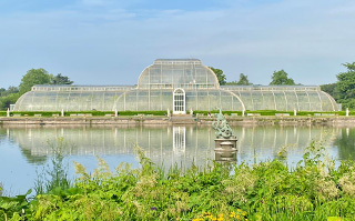 A view of the pond and glass house at Kew Gardens in England.