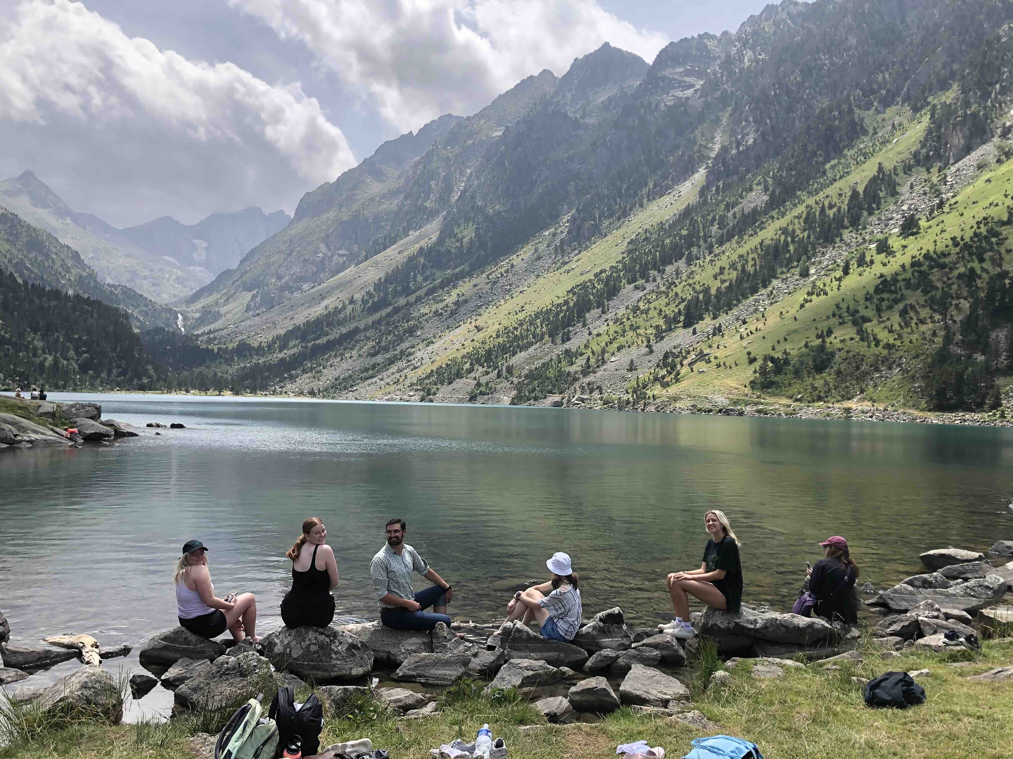 A group of students enjoying the lake and mountain scenery in Pau, France.