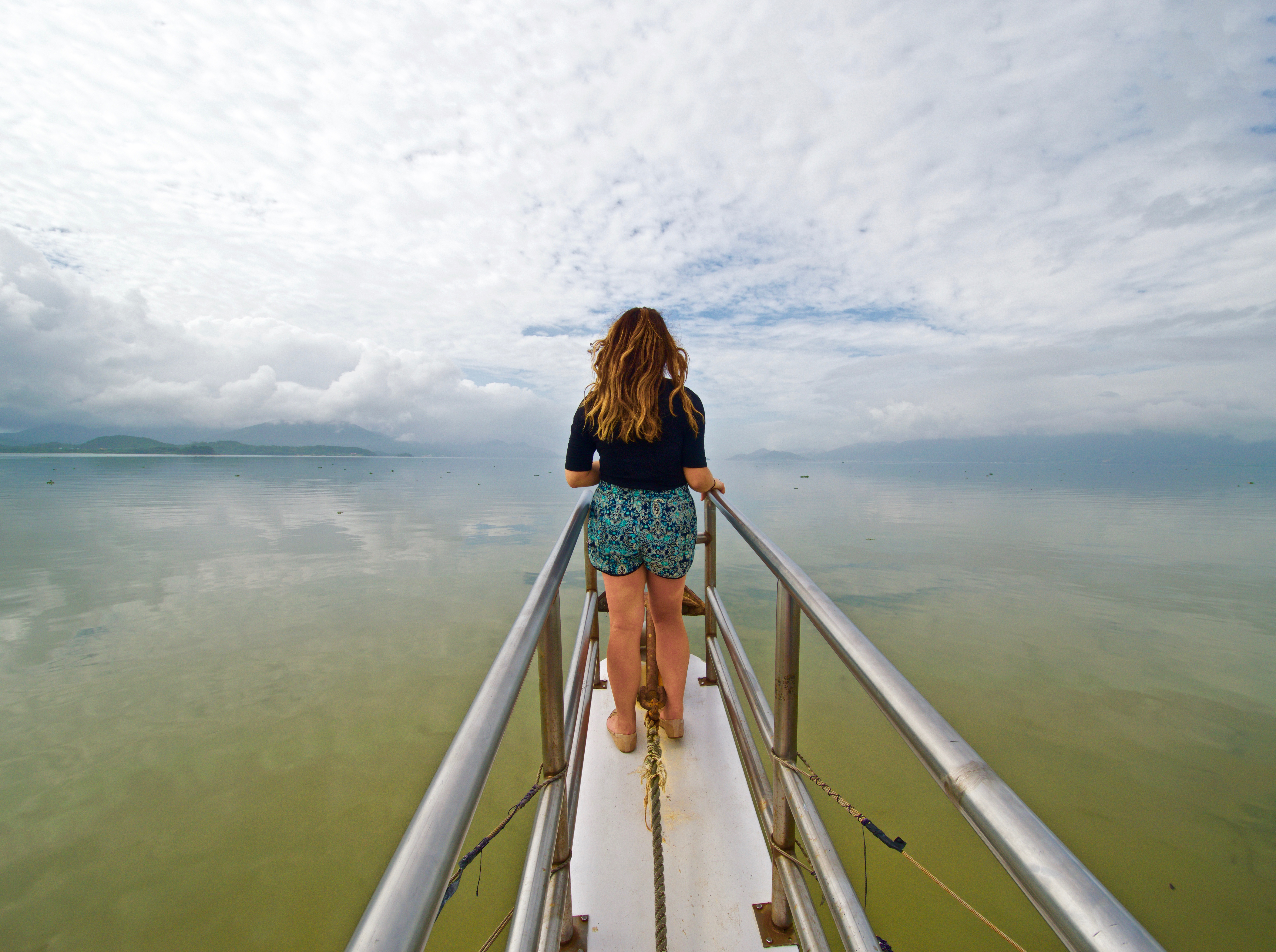 Student standing at the front of a boat overlooking the water in Floripa.
