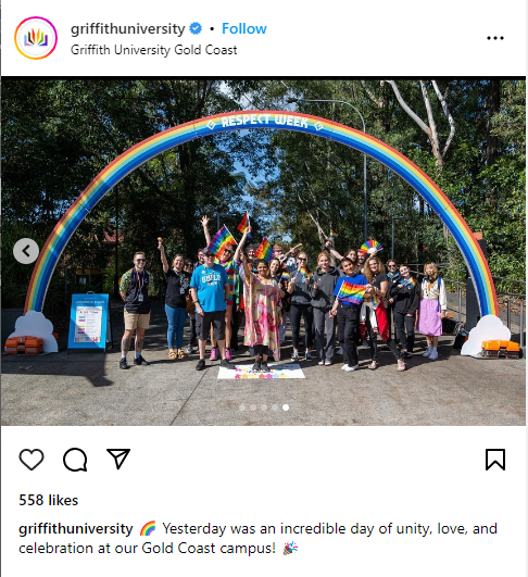 People standing under a rainbow arch holding Pride flags at the Pride festival at Griffith University in Australia
