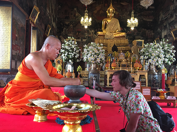 A monk blessing someone in a temple.
