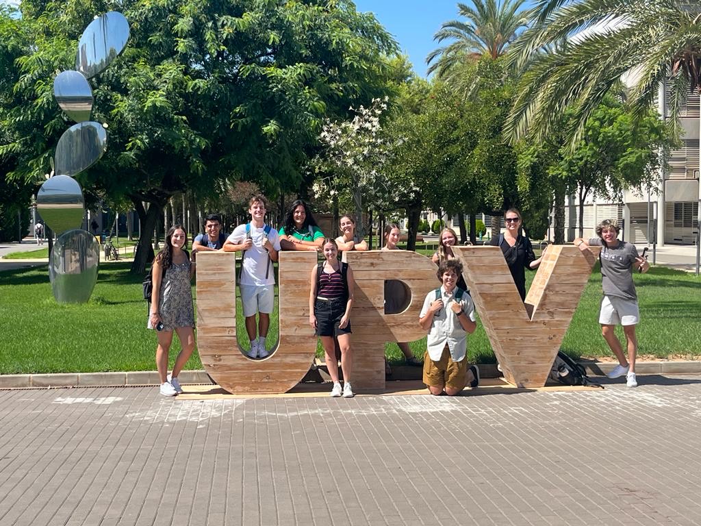 A group of University of Maine students standing next to the UPV (Universitat Politècnica de València) sign in Valencia, Spain..