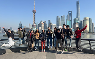 Students jumping with a view of the cityscape of Shanghai, China in the background.