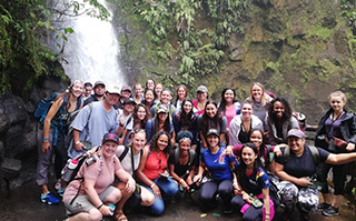 Students posing in front of the La Paz waterfall in Costa Rica.