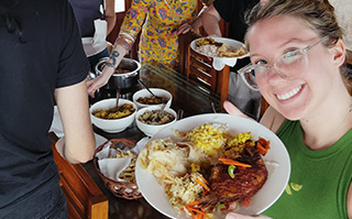 A person holding a plate of traditional Indian food in India.