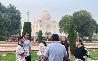 Students on a tour with the Taj Mahal in the background in India.