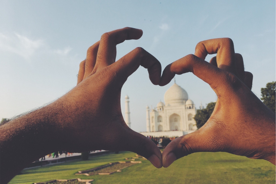 Hands creating a heart shape with the Taj Mahal on the inside.