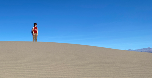 Ashleigh Patton standing on top of a sand mountain.