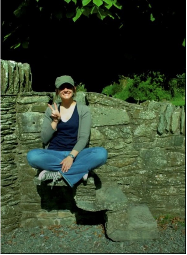 Brittney Chesher sitting on a rock wall in Belfast, Ireland.