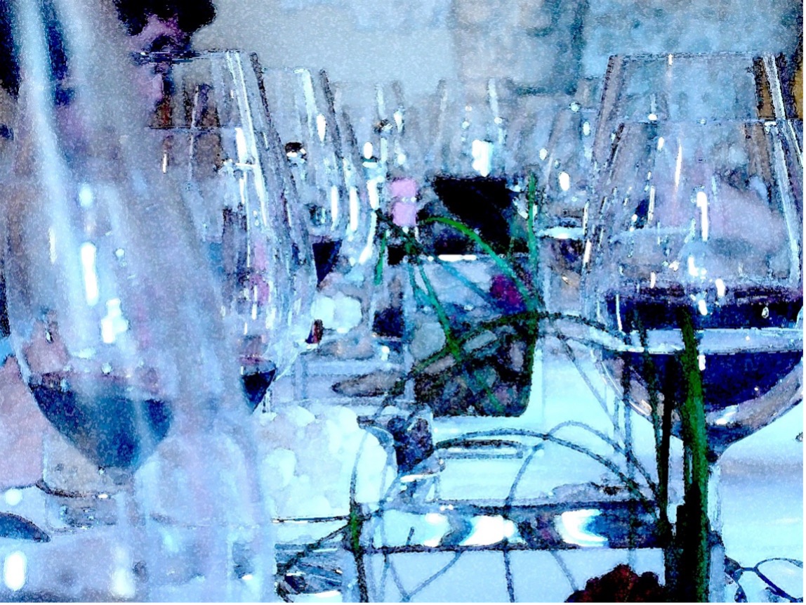 A view of wine glasses lined up on a dinner table.