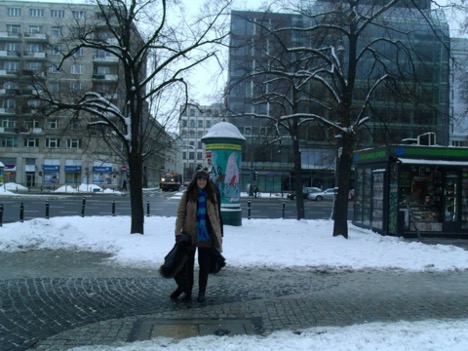 Stephanie Sietz in a long coat with buildings in the background and snow on the ground in Poland.