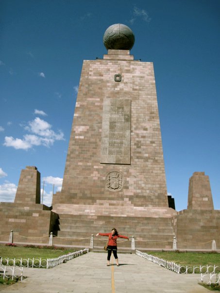 Kelsey standing in front of a historic monument in Ecuador.