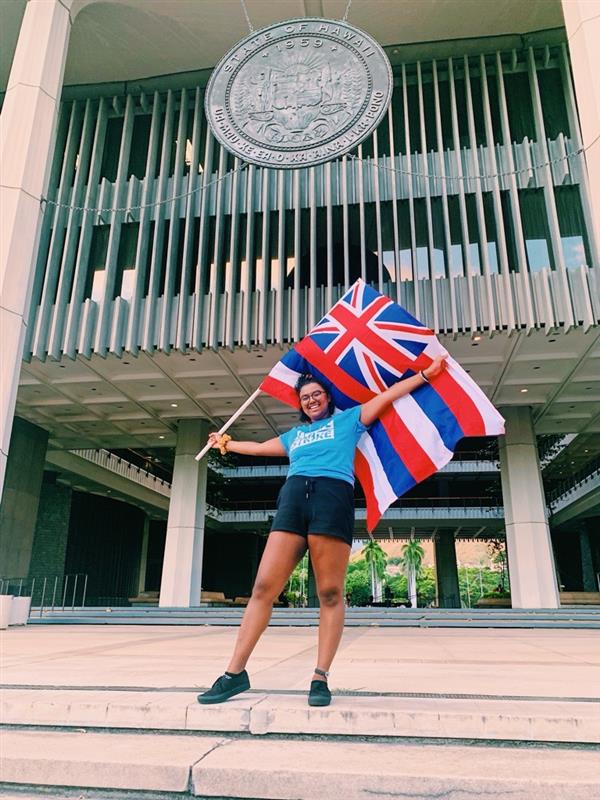 Kiana holding a flag in Hawaii.