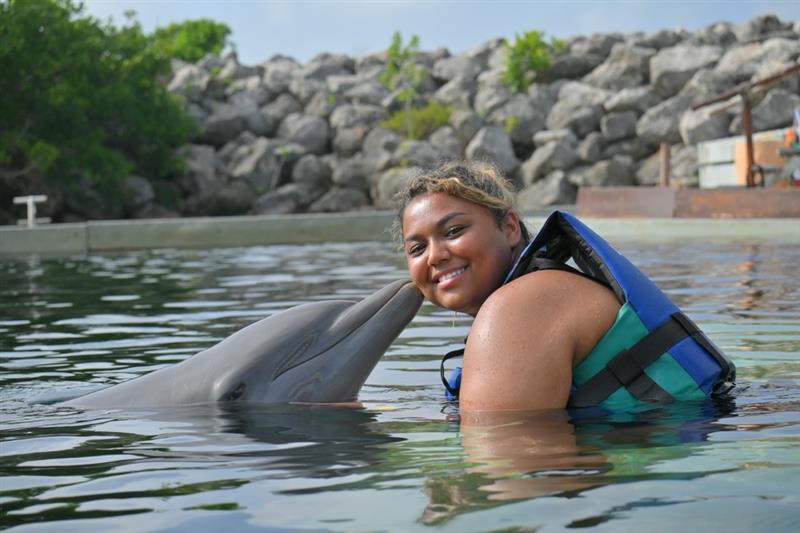 Kiana swimming with dolphins in Mexico.