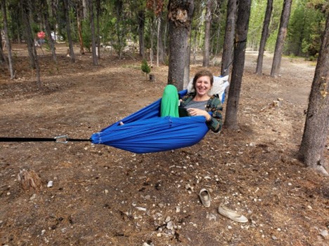Laura Conneau relaxing on a hammock in the woods.