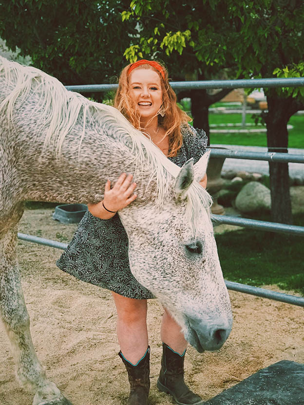 Phoebe standing with a horse.