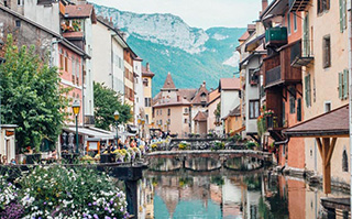 View of historic buildings lining a river in France.