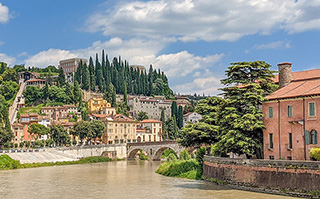 View of historic buildings lining a river in Italy.