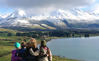 Students overlooking a lake an snow-covered mountains in New Zealand.