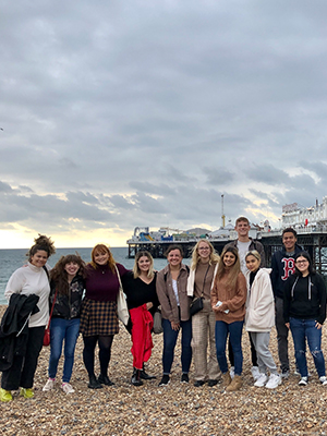 Students on the beach in front of Brighton Pier in Brighton, England.