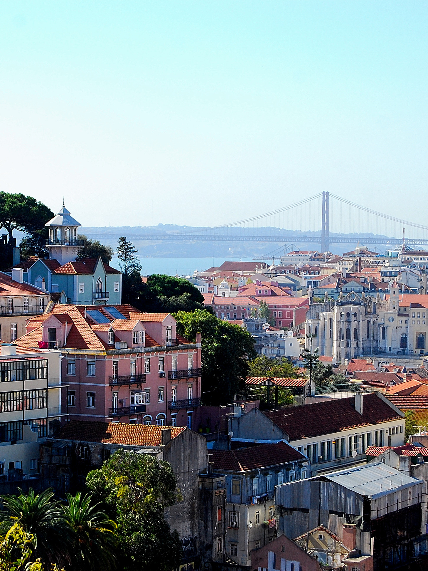 Buildings on the hillside with a view of the sea and bridge in Lisbon, Portugal.