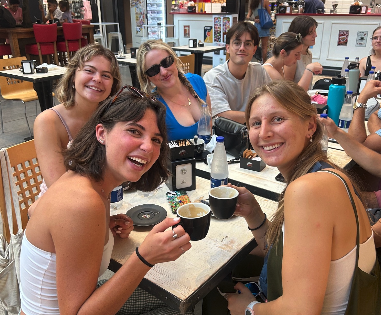 A group of students sitting at a table having a meal together in Torino, Italy.