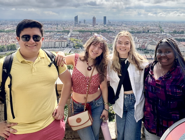 A group of students posing together overlooking the city of Lyon, France.