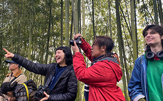 Three people looking off into the distance with bamboo in the background in China.