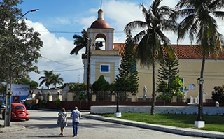 Two people walking down the street in La Habana, Cuba.