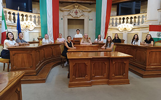 Students sitting at desks with Italian flags behind them in Reggio Emilia, Italy.