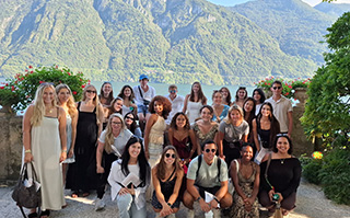 Students in front of a mountain lake in Italy.