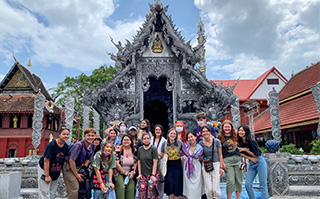 A group of students in front of a traditional Thai Wat in Chiang Mai, Thailand.
