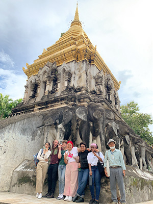A group of students standing in front of a traditional Thai Wat in Chiang Mai, Thailand.