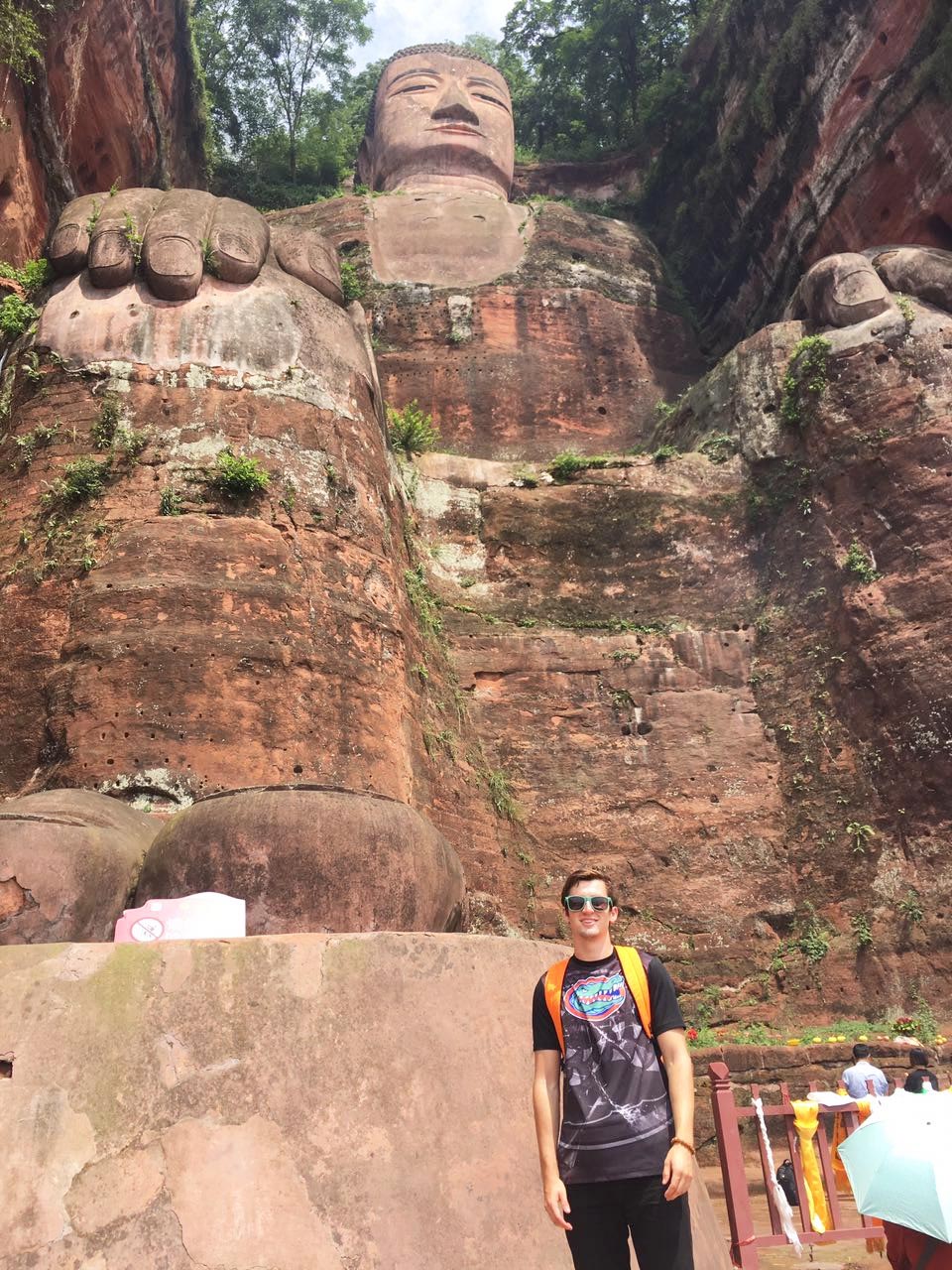 Student standing in front of the world's largest sitting Buddha in Leshan, China.