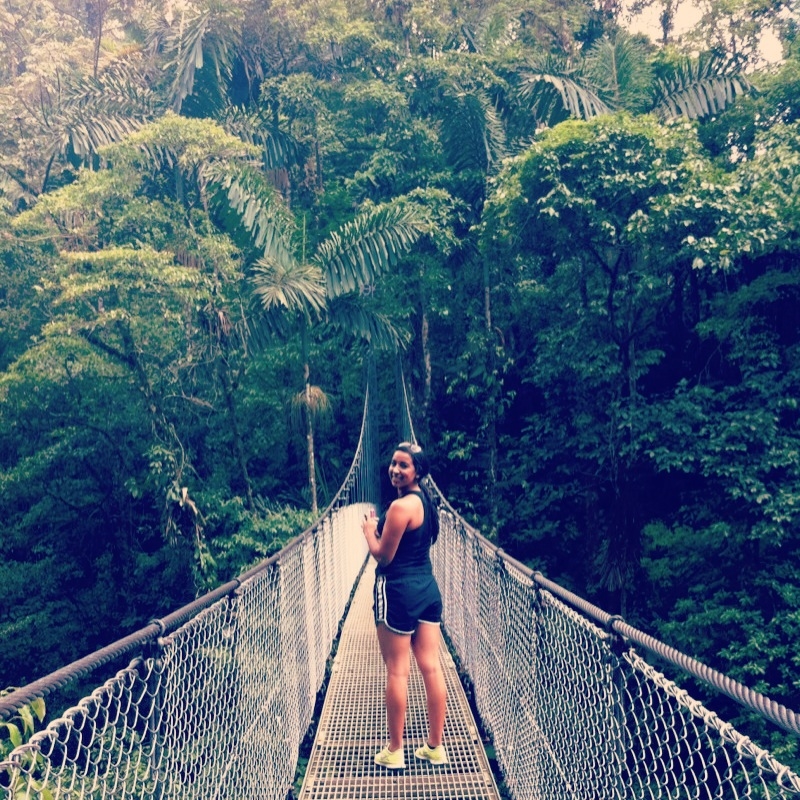 Student standing in the middle of the Arenal hanging bridge in Heredia, Costa Rica