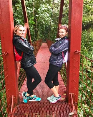 Two students standing on a red bridge in Costa Rica.