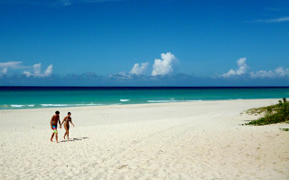 Two people walking on the beach of Santa Maria del Mar in Cuba.