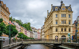 A view of the river, a bridge, and historic buildings in Karlovy Vary, Czech Republic.