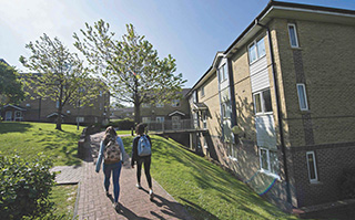 Students walking outside Paddock Field, a student residence hall at the University of Brighton in Brighton, England.