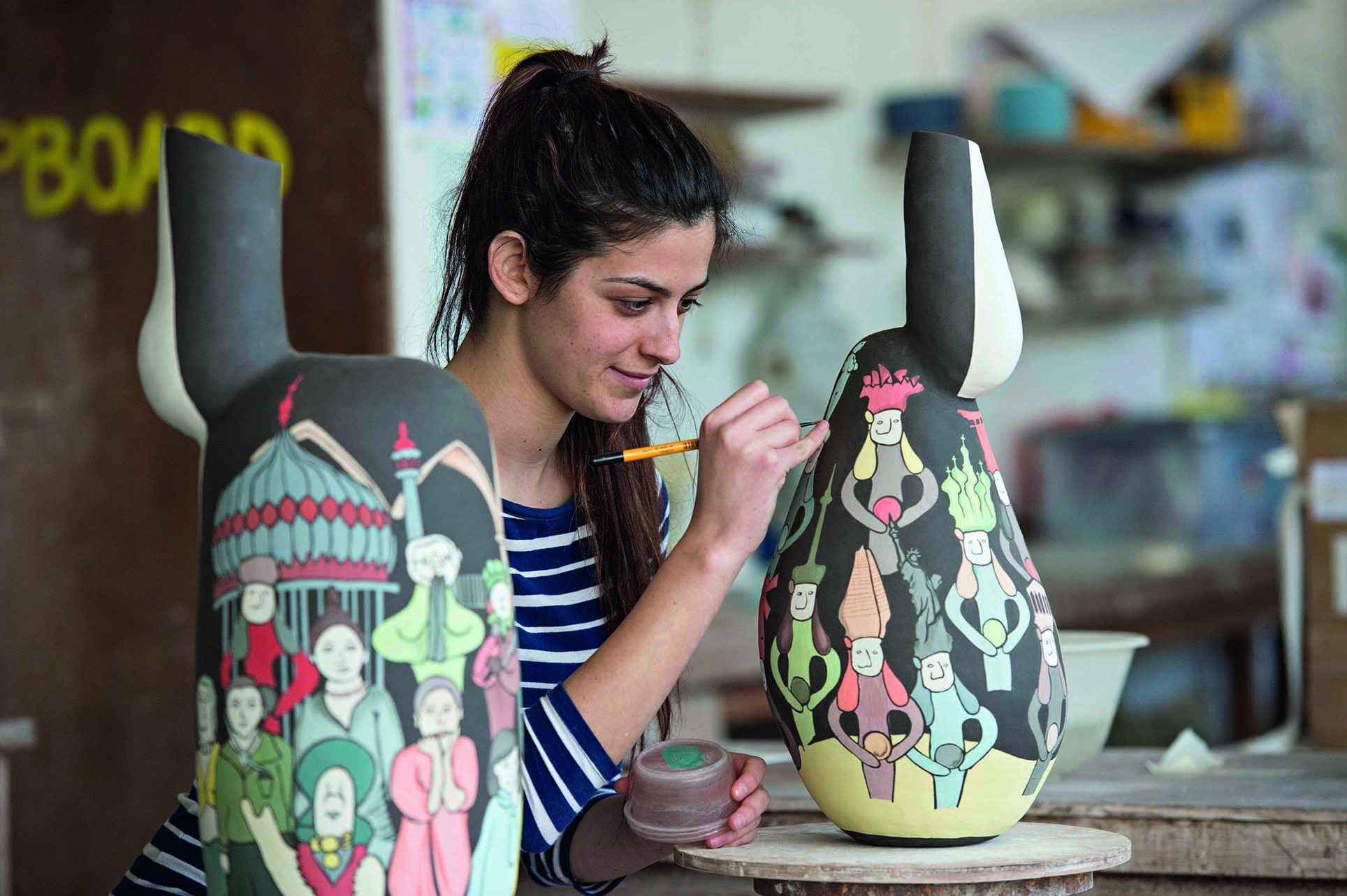 A student painting pottery in class at the University of Brighton in Brighton, England.