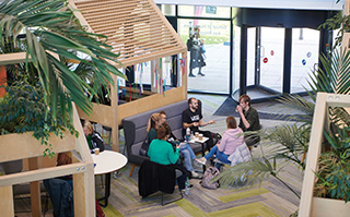 Students sitting in the Checkland building common area at the University of Brighton in Brighton, England.