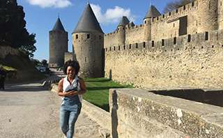 A woman walking in front of the Carcassonne medieval castle in Toulouse, France.