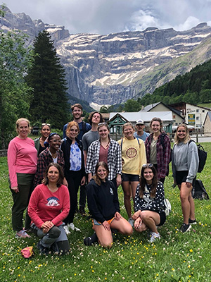A group of students posing with the Pyrenees mountains in the background. 