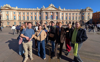 Students in front of a historic building in Toulouse, France.