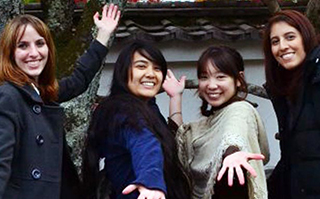 Four people posing together in front of a historic Japanese building in Nishinomiya, Japan.