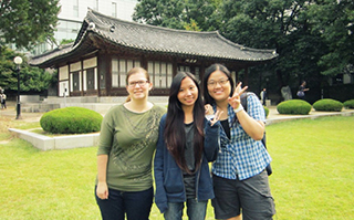 Three people posing together in front of a historic Korean building on the Yonsei campus in Seoul, Korea.