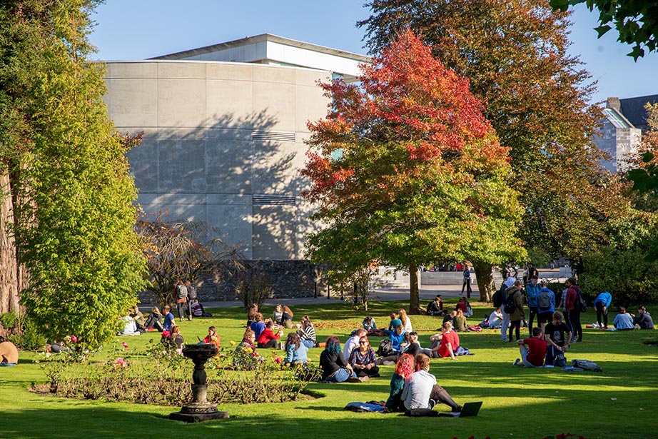 Students sitting on the lawn at University College Cork campus in Cork, Ireland.